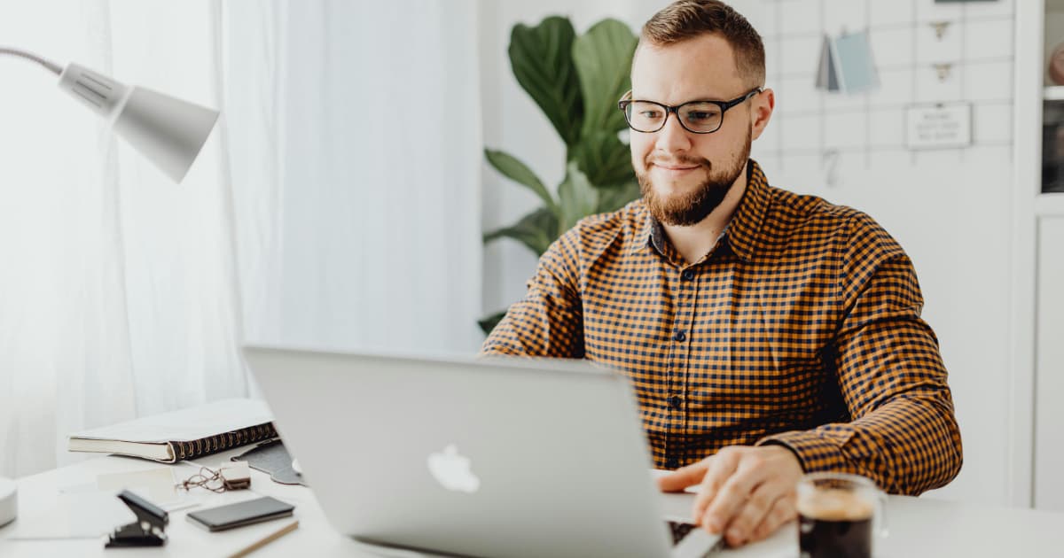 Freelancer using invoicing software on laptop at modern workspace