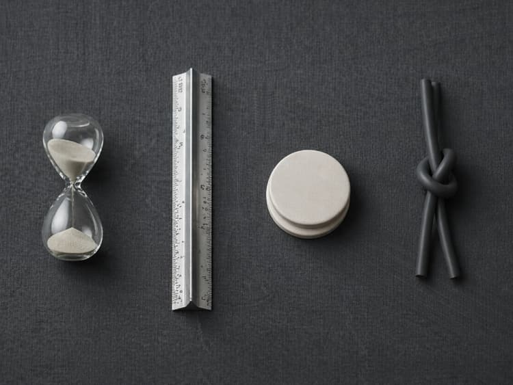 Overhead sequence of hourglass, ruler, stacked tokens, and knotted cable on linen suggesting onboarding steps