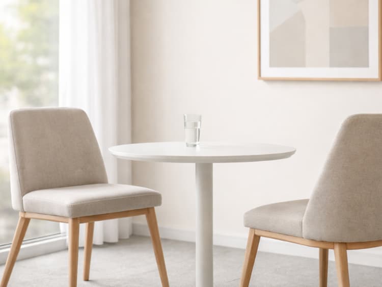 Empty two-chair meeting nook with daylight, suggesting steady client collaboration and clear ongoing terms