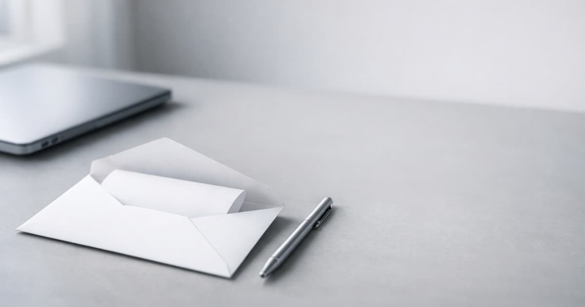 A professional envelope with a folded document on a clean desk, suggesting sending an invoice by email