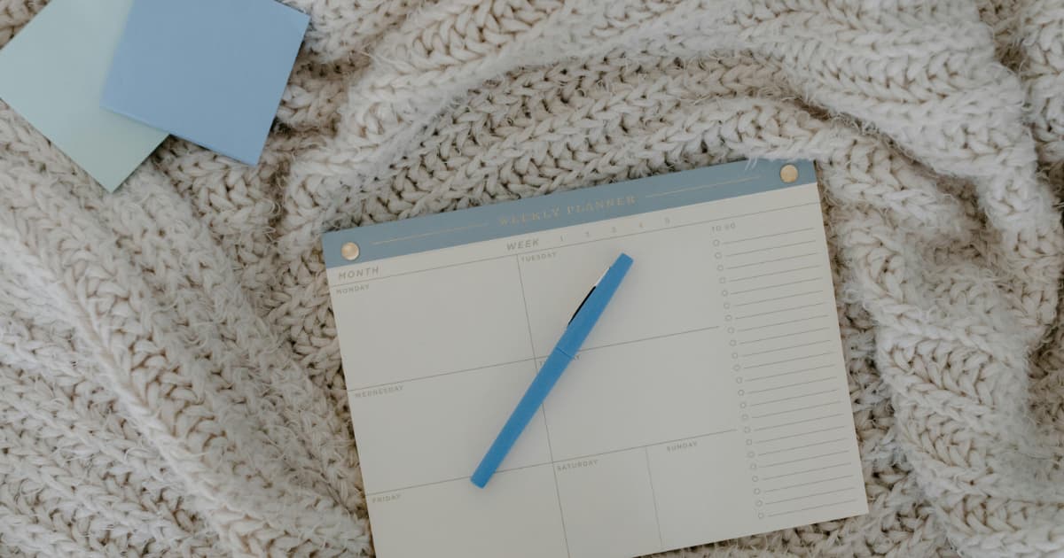 Weekly planner with pen for tracking invoice due dates