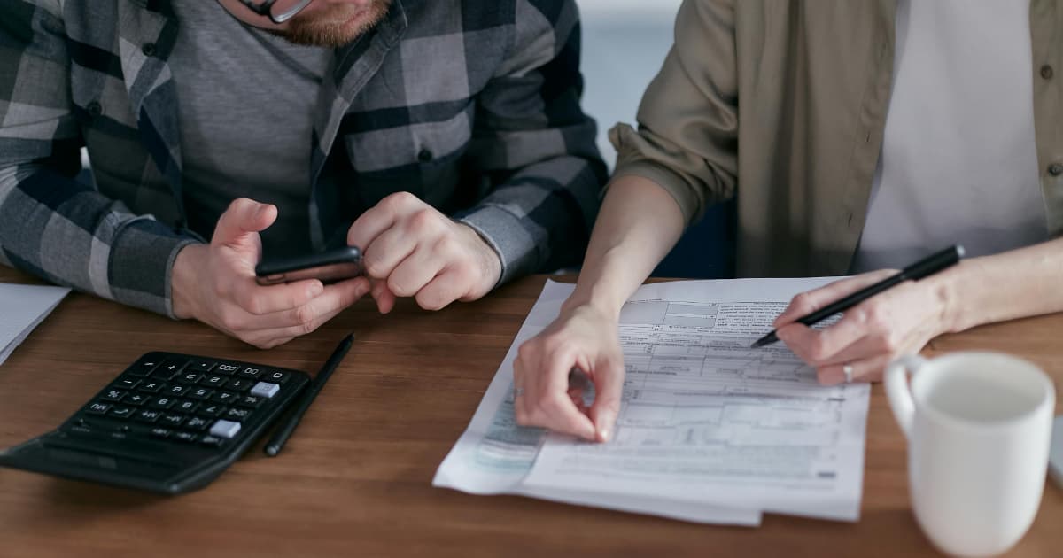 Two people reviewing invoice documents and payment terms together