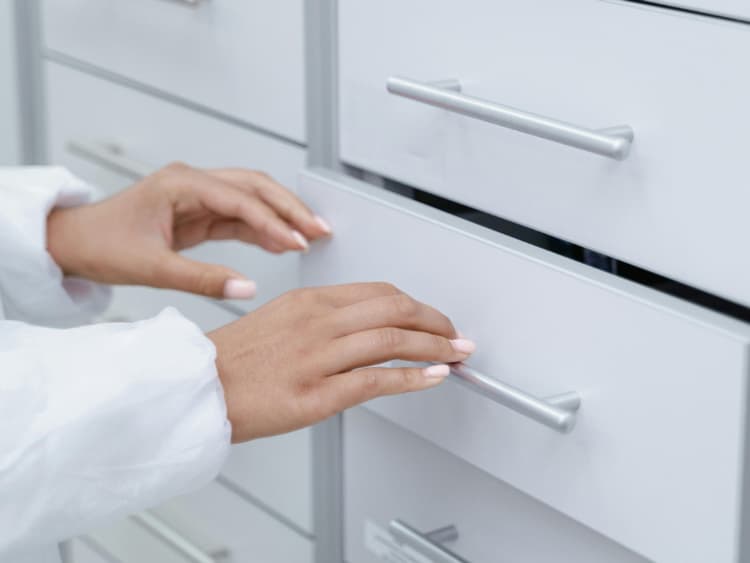 Hands opening organized filing cabinet drawer