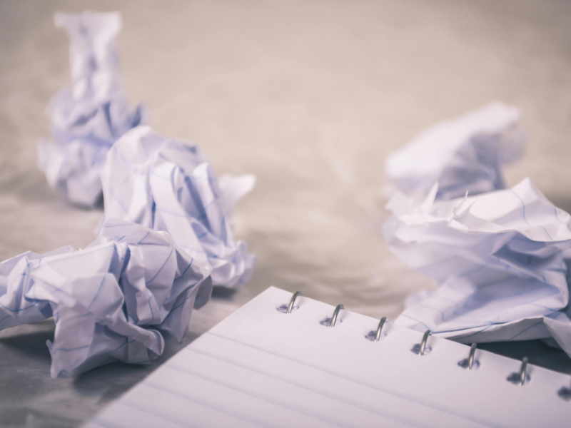Crumpled papers and blank notebook representing messy undefined project scope