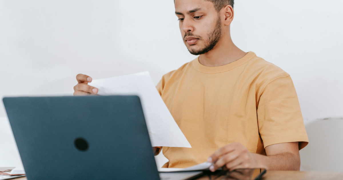 Freelancer reviewing project terms at a laptop in a modern workspace