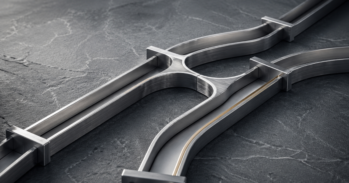Brushed metal split channels on stone suggesting multiple payment routes, lit like a premium editorial product photo