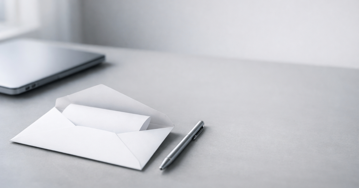 A professional envelope with a folded document on a clean desk, suggesting sending an invoice by email