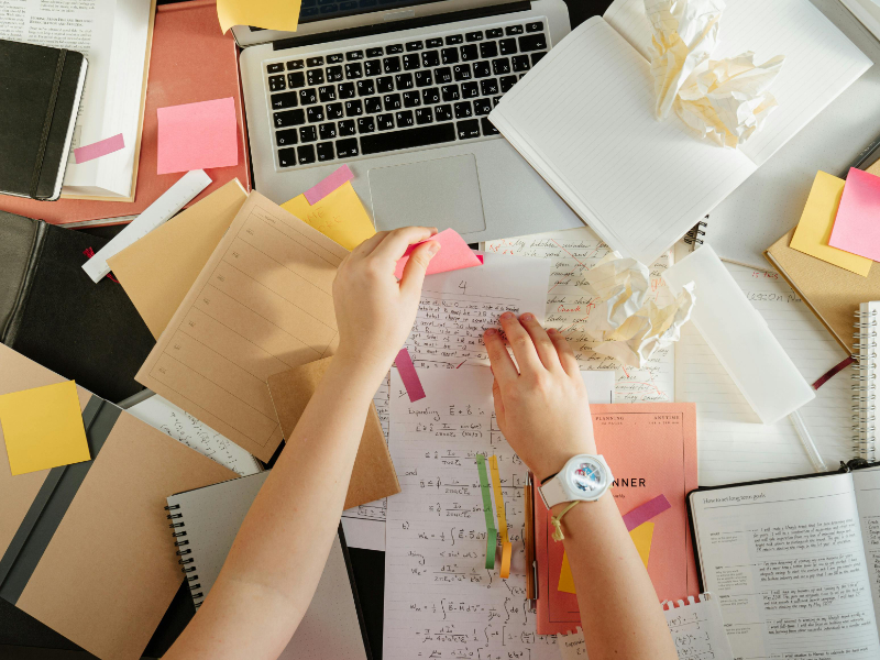 Messy desk with paperwork and laptop