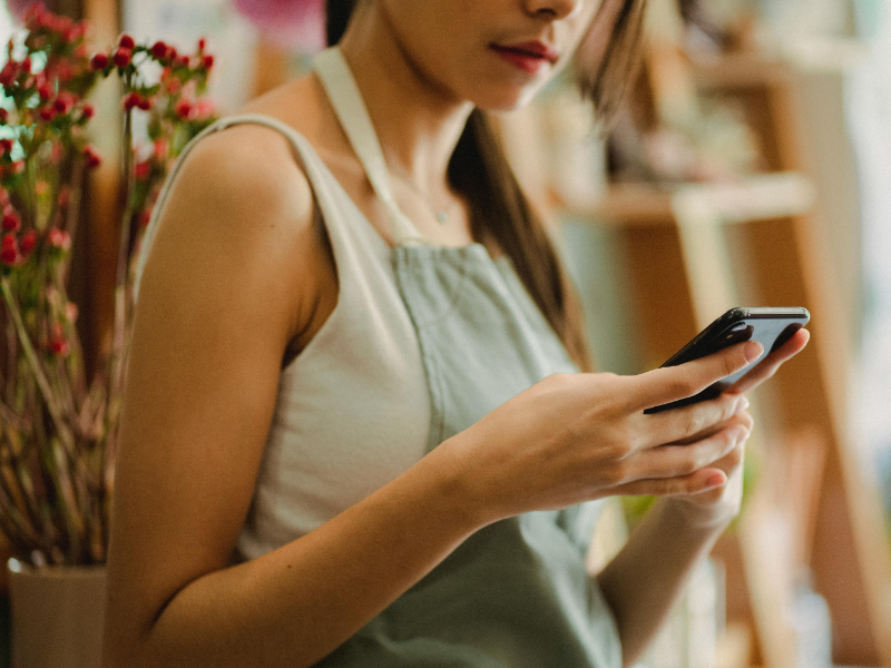 Small business owner sending invoice from phone